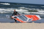 Windsurfer on the beach with board and sail
